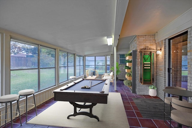 recreation room with brick wall, vaulted ceiling, plenty of natural light, and billiards