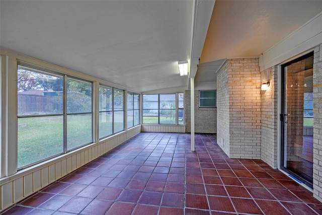 unfurnished sunroom featuring vaulted ceiling and a healthy amount of sunlight