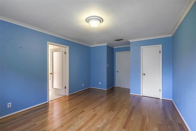 unfurnished bedroom with hardwood / wood-style flooring, ornamental molding, a textured ceiling, and a closet