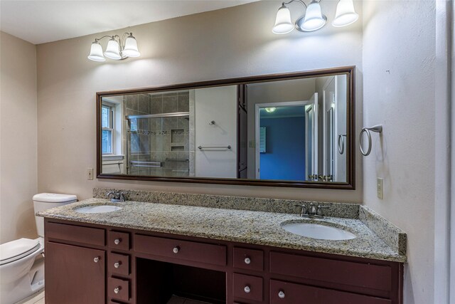 bathroom with vanity, toilet, and a shower with door