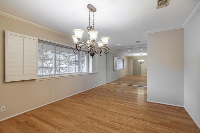 unfurnished dining area featuring ornamental molding, an inviting chandelier, and light hardwood / wood-style floors