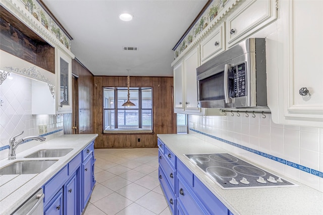 kitchen featuring sink, blue cabinetry, appliances with stainless steel finishes, white cabinetry, and decorative light fixtures