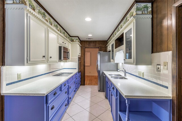 kitchen with blue cabinets, appliances with stainless steel finishes, sink, and white cabinets