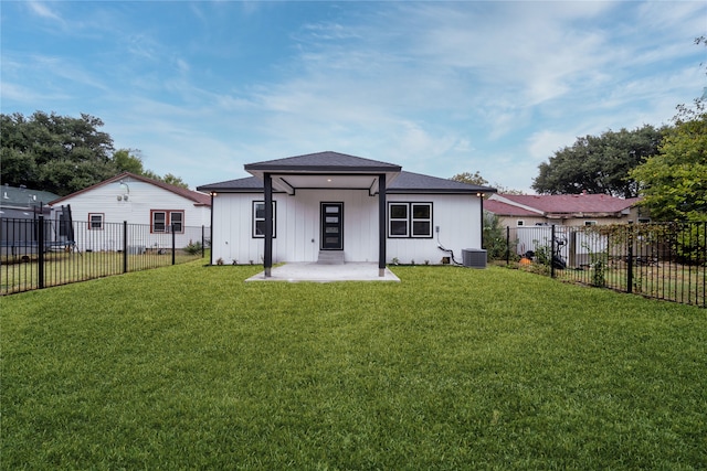 rear view of house featuring a lawn and cooling unit