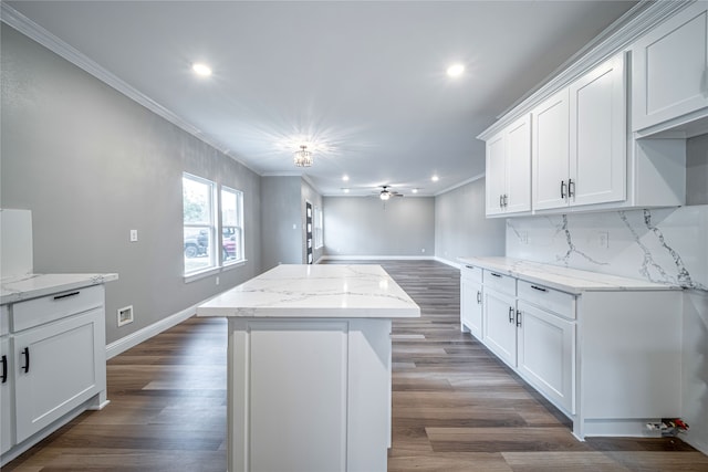 kitchen with white cabinetry, light stone counters, dark hardwood / wood-style flooring, and a kitchen island