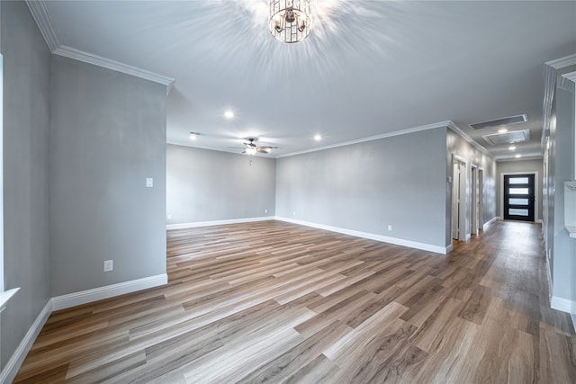 empty room with ornamental molding, light hardwood / wood-style flooring, and ceiling fan with notable chandelier