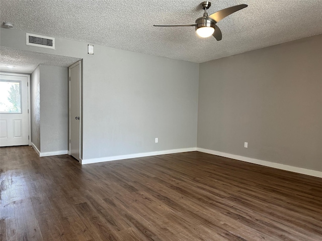 spare room featuring a textured ceiling, ceiling fan, and dark wood-type flooring