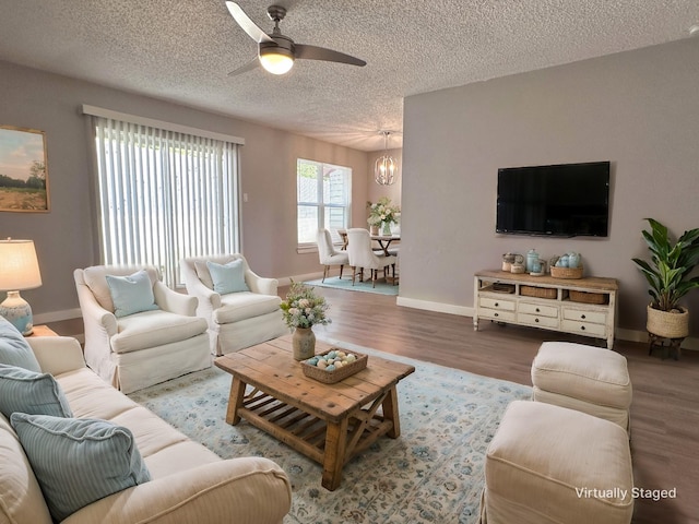 living room with a textured ceiling, hardwood / wood-style floors, and ceiling fan with notable chandelier