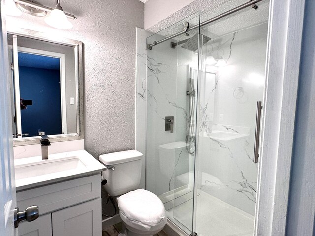 bathroom featuring vanity, toilet, and walk in shower