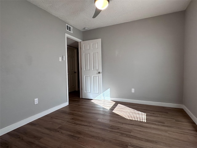 unfurnished room featuring ceiling fan, dark hardwood / wood-style flooring, and a textured ceiling