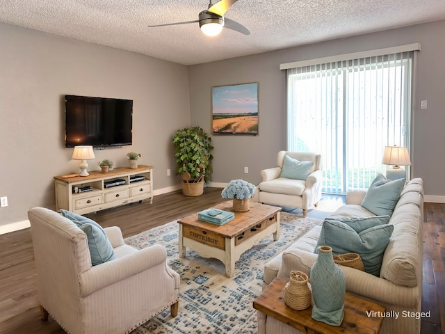 living room with ceiling fan, dark hardwood / wood-style flooring, and a textured ceiling