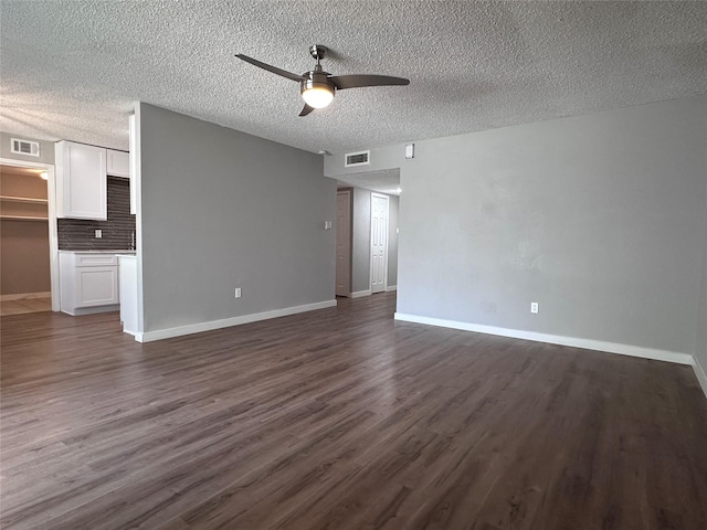 unfurnished living room featuring a textured ceiling, ceiling fan, and dark wood-type flooring