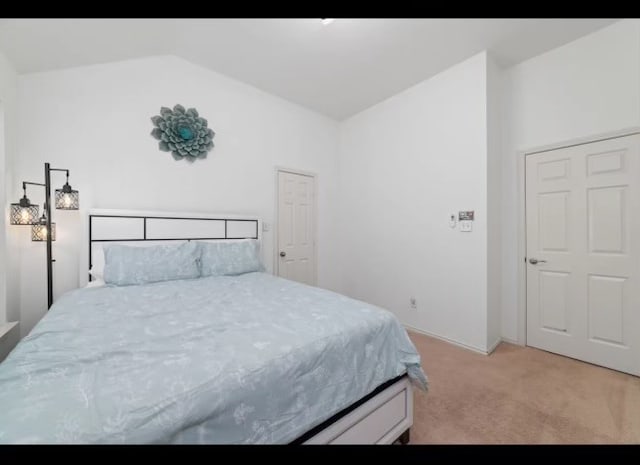 carpeted bedroom featuring lofted ceiling