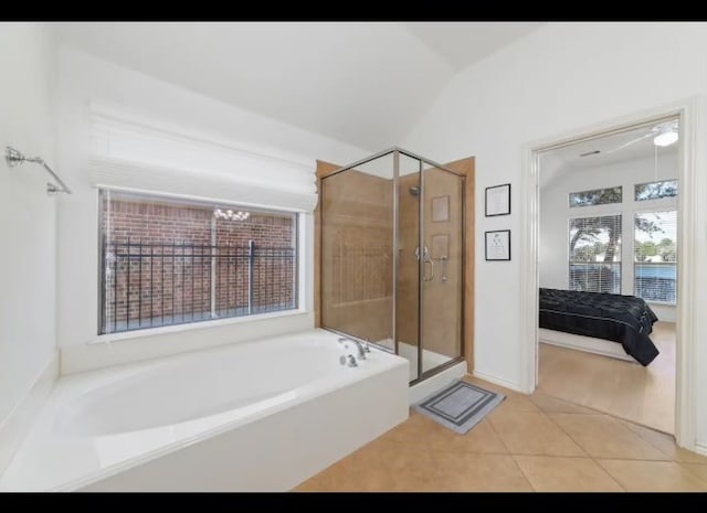 bathroom featuring independent shower and bath, vaulted ceiling, and tile patterned flooring