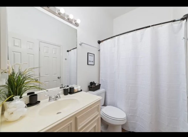 bathroom featuring vanity, toilet, and walk in shower