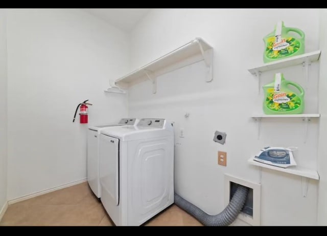 laundry area featuring washer and dryer and light tile patterned floors