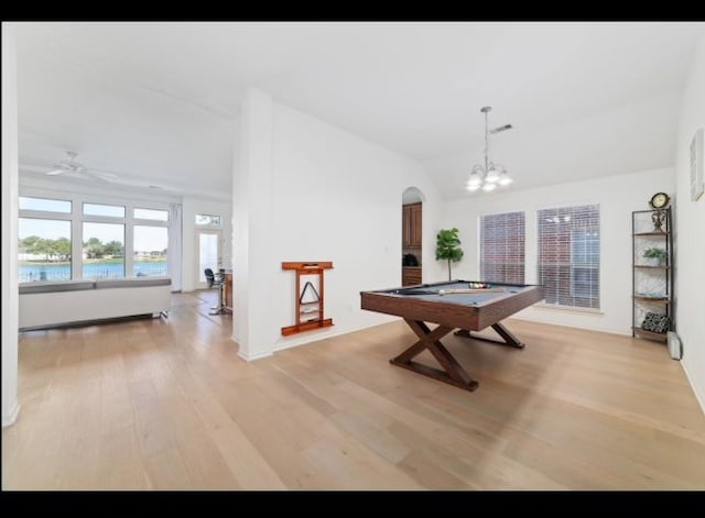 game room with ceiling fan with notable chandelier, light hardwood / wood-style floors, lofted ceiling, a water view, and billiards