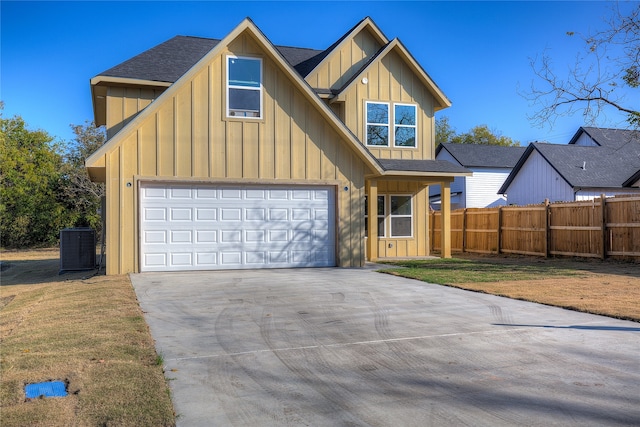 view of front of home featuring central air condition unit, a front lawn, and a garage