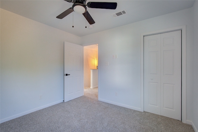 unfurnished bedroom with a closet, ceiling fan, and light colored carpet