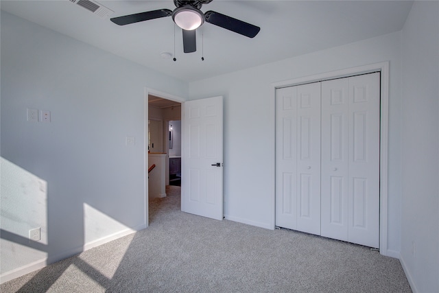 unfurnished bedroom featuring a closet, ceiling fan, and light carpet