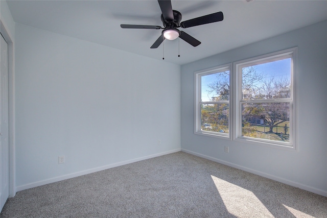 empty room with ceiling fan and carpet