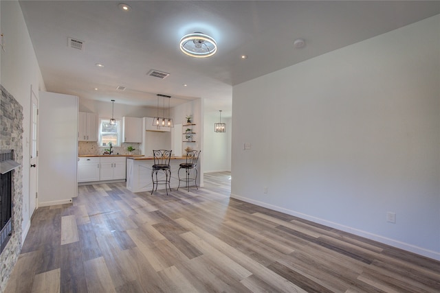 unfurnished living room featuring sink, light hardwood / wood-style flooring, and a fireplace