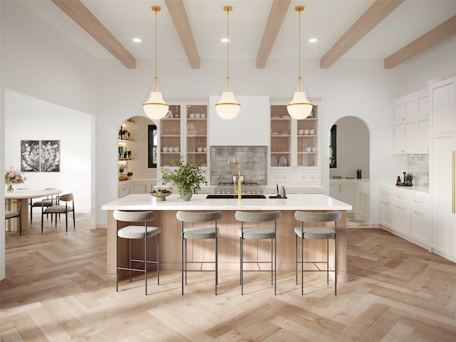 kitchen with hanging light fixtures, tasteful backsplash, a large island, beam ceiling, and a breakfast bar area