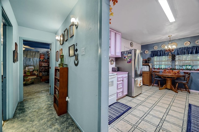 kitchen with an inviting chandelier, white appliances, and decorative light fixtures