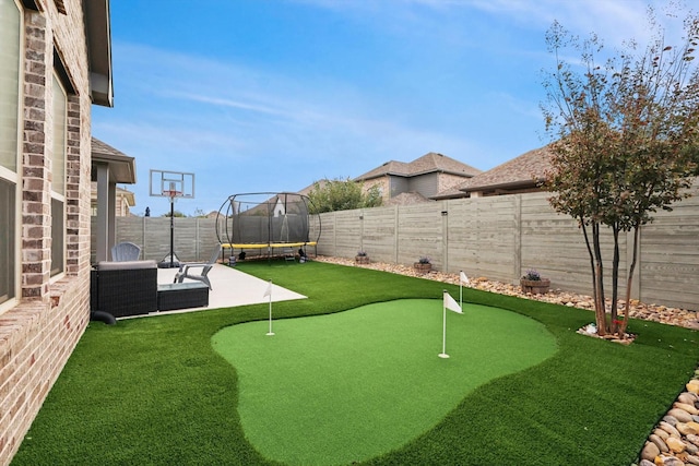 view of yard with a patio area, a fenced backyard, a trampoline, and an outdoor living space