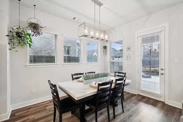 dining room featuring a wealth of natural light, baseboards, a chandelier, and dark wood-style flooring