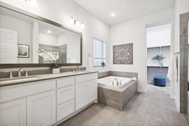 full bathroom featuring a garden tub, a sink, a shower stall, tile patterned floors, and double vanity