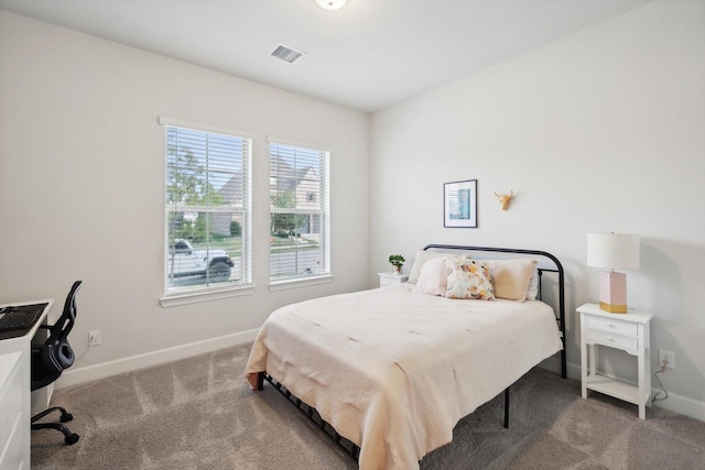 bedroom with carpet floors, visible vents, and baseboards