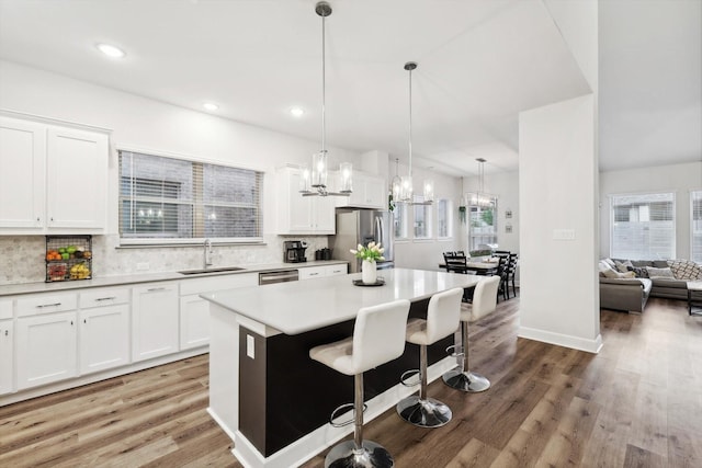 kitchen featuring appliances with stainless steel finishes, a kitchen island, a sink, and white cabinets