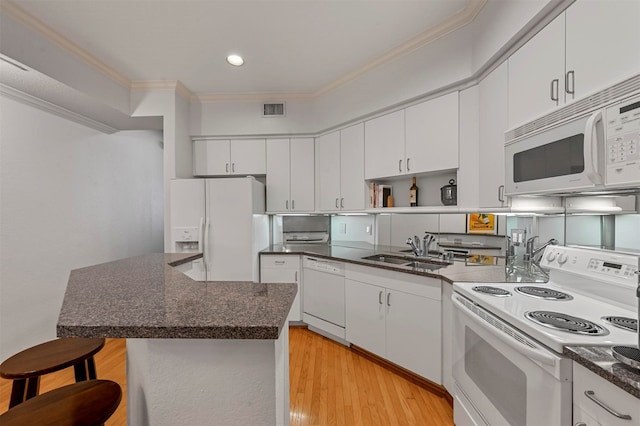 kitchen with a kitchen breakfast bar, white cabinetry, light wood-type flooring, sink, and white appliances