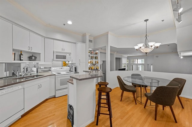 kitchen featuring light hardwood / wood-style flooring, white cabinets, sink, and white appliances