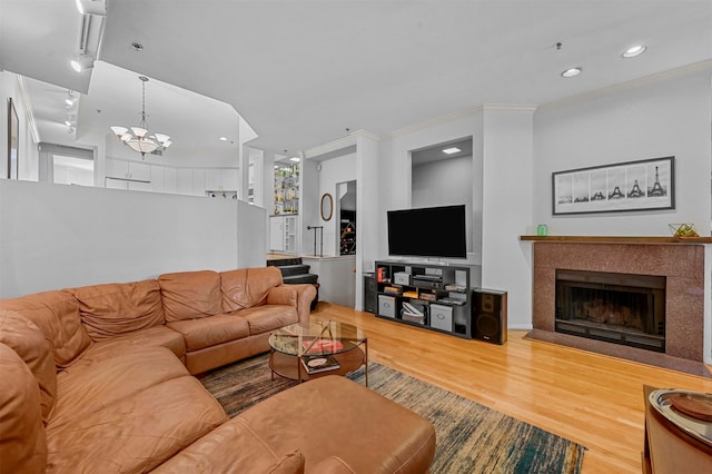 living room with ornamental molding, a notable chandelier, and hardwood / wood-style floors