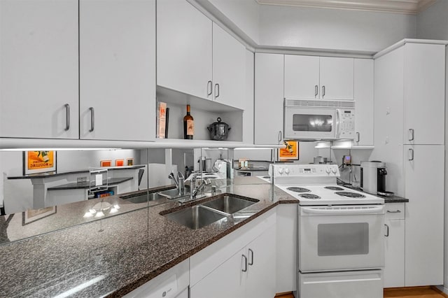 kitchen with white cabinetry, dark stone counters, crown molding, sink, and white appliances