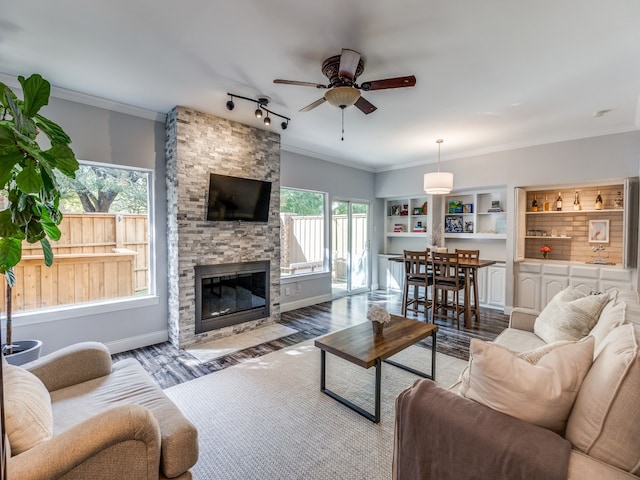 living room with ceiling fan, a stone fireplace, light hardwood / wood-style flooring, and plenty of natural light