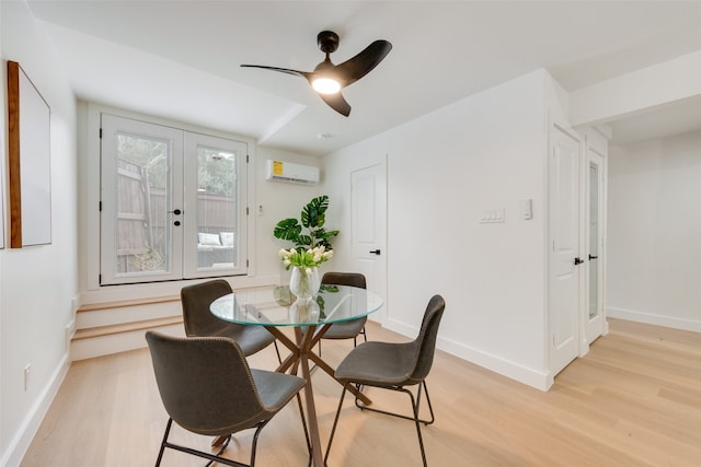 dining area featuring french doors, ceiling fan, a wall unit AC, and light hardwood / wood-style flooring