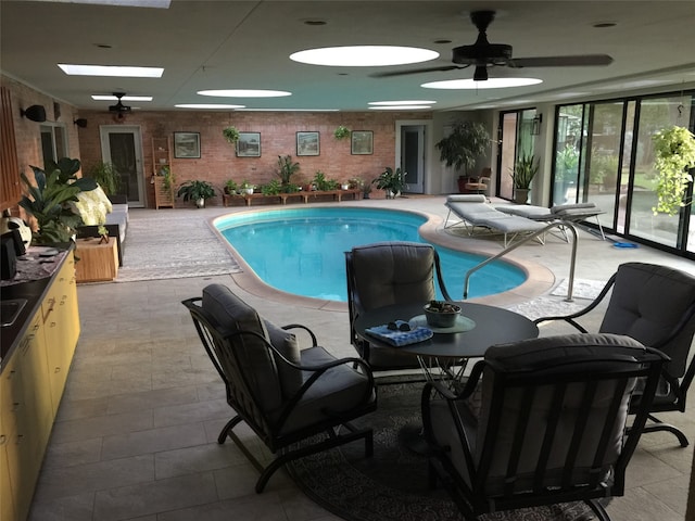 view of pool with ceiling fan and a skylight