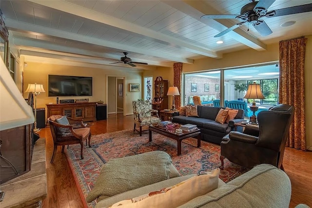 living room featuring beamed ceiling, hardwood / wood-style floors, and ceiling fan