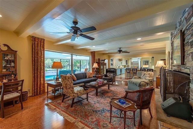 living room featuring beam ceiling, hardwood / wood-style floors, and ceiling fan