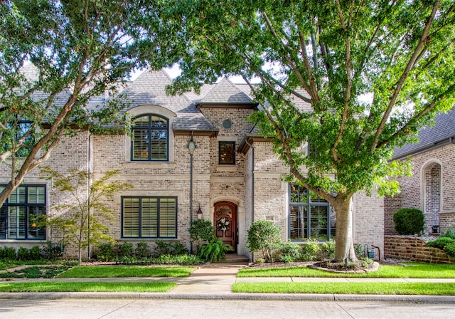 french provincial home featuring a front lawn