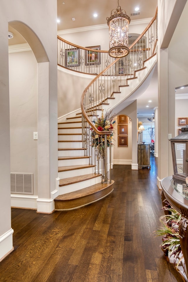 entrance foyer featuring crown molding, dark hardwood / wood-style flooring, and a high ceiling