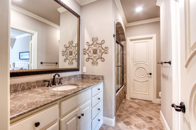 full bathroom featuring toilet, vanity, enclosed tub / shower combo, and ornamental molding