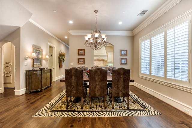 dining area with a chandelier, dark hardwood / wood-style floors, and crown molding