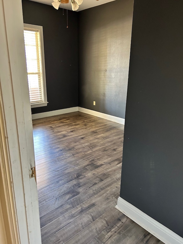 empty room with dark hardwood / wood-style floors and ceiling fan