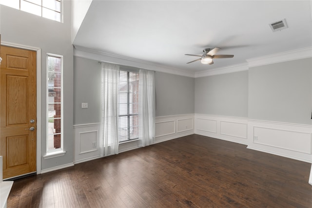 foyer entrance featuring a wealth of natural light, ornamental molding, and dark hardwood / wood-style floors