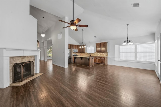2221 Pittner Ln, Plano, TX 75025 - unfurnished living room with a chandelier, ceiling fan, a fireplace, dark wood-style flooring, and high vaulted ceiling
