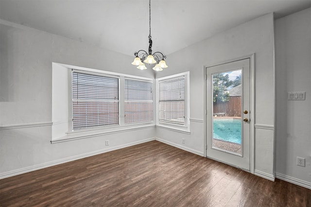 unfurnished dining area with dark hardwood / wood-style flooring and a chandelier